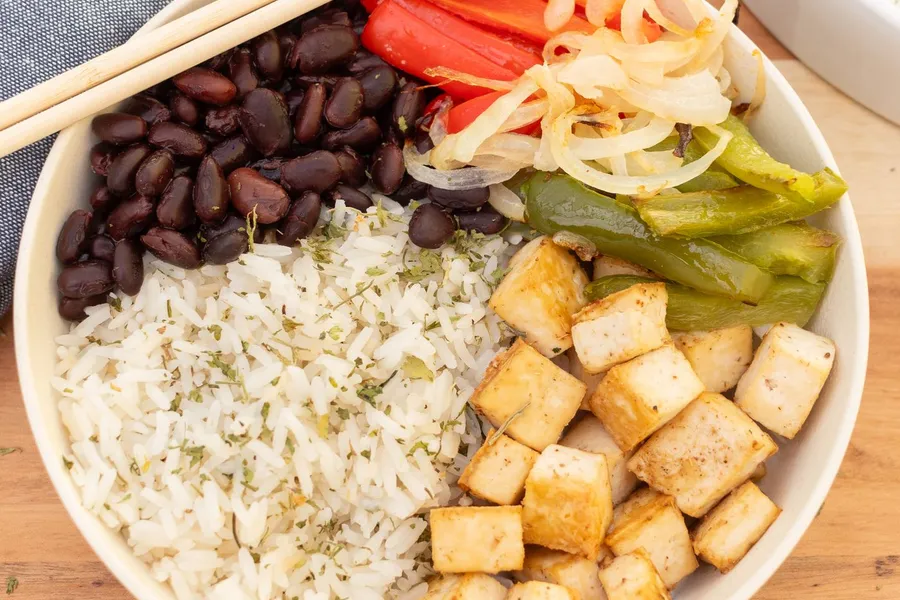 Rice bowl with tofu, beans, vegetables, and sauce