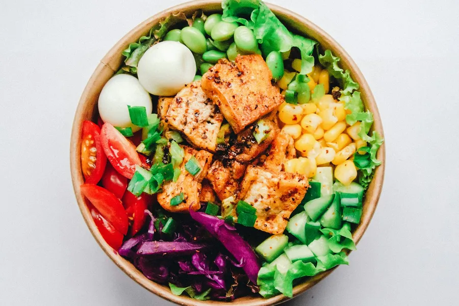 Colorful bowl with rice, vegetables, and fresh toppings